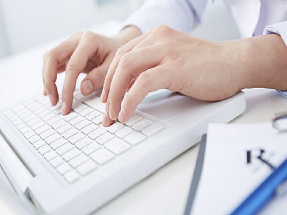 Hands typing on a computer